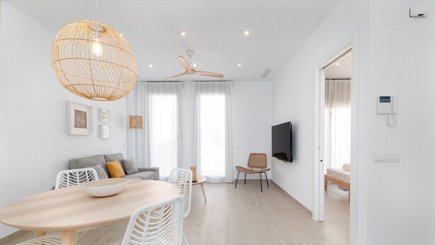 A modern, well-lit room with a dining table, white chairs, a ceiling fan, and a flat-screen TV mounted on the wall. - Ca Celieta Beach II. WiFi+ Aire Acondicionado (Valencia / València)