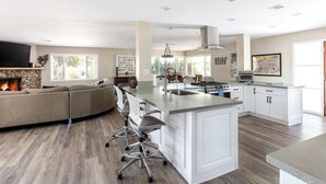 Een moderne keuken met een centraal eiland, een ingebouwde kookplaat en een groot raam.