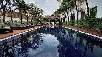 Una piscina interior tranquila con sillones de descanso y un arco decorativo.
