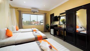 A hotel room with two beds, a desk, a TV, and a large mirror.