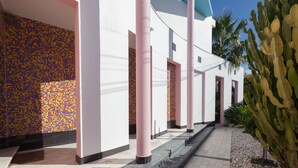 A building with a tiled mosaic wall, a cactus garden, and a tiled pathway leading to the entrance. - FLH Caparica Town House with Pool (Charneca de Caparica)