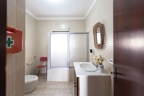 Une salle de bain avec des toilettes, une douche et un lavabo.
