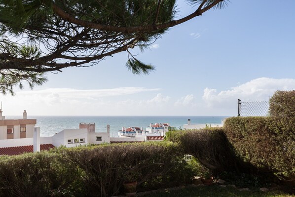 Une vue sur la côte, avec un ciel dégagé, une plage et des bâtiments en arrière-plan.