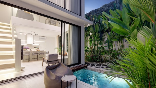 Ein modernes Haus mit Pool, Essbereich und Küche.