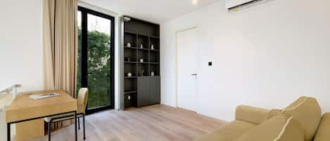 Una sala moderna con una mesa de comedor de madera, un sofá beige y una estantería empotrada.