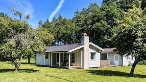 A single-story house with a porch, a chimney, and a well-maintained lawn. - Beautiful home in Färjestaden with WiFi (Färjestaden)
