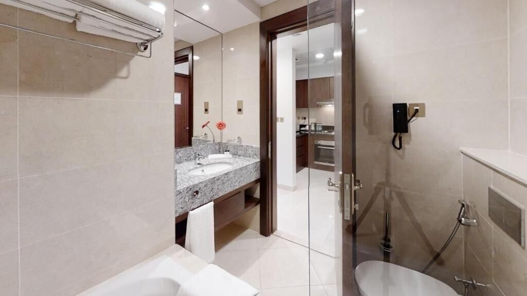 A modern bathroom with a glass shower enclosure, a vanity with a sink, and a toilet.