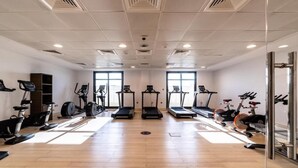 A gym with treadmills, stationary bikes, and elliptical machines.