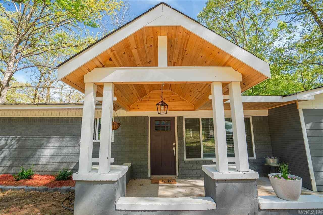 Une maison moderne dotée d’un porche abrité, d’une porte d’entrée et d’un petit jardin.