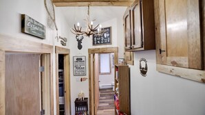 A wooden interior hallway with a chandelier, wooden cabinets, and various signs. - KingBed+Cabin+quiet+new renovation+foliage+ski (Lake Harmony)