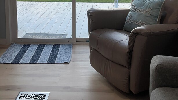Una habitación con puerta corrediza de vidrio que da a una terraza con vista a la playa.