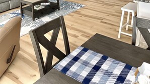 Una sala de estar con chimenea, un televisor de pantalla plana, un sofá, una mesa de centro y un comedor con sillas.