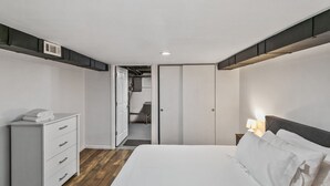 A bedroom with a bed, a dresser, a nightstand, and a closet. - Lovely Duplex in DT Libertyville Near Naval Base! (Libertyville)