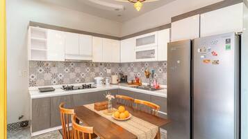 A modern kitchen with a central island, stainless steel appliances, and a decorative ceiling light.