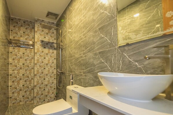 A bathroom with a white sink, a toilet, and a shower with patterned tiles. - Hoi An Lazy Bear Hostel (Da Nang)