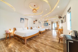 A hotel room with a wooden floor, a bed, a desk, and a kettle. - Hoi An Lazy Bear Hostel (Da Nang)
