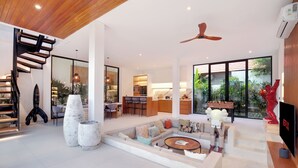 A spacious living area with a modern staircase, a dining area, and a kitchen. - Paradise Living Villa Canggu (Canggu)