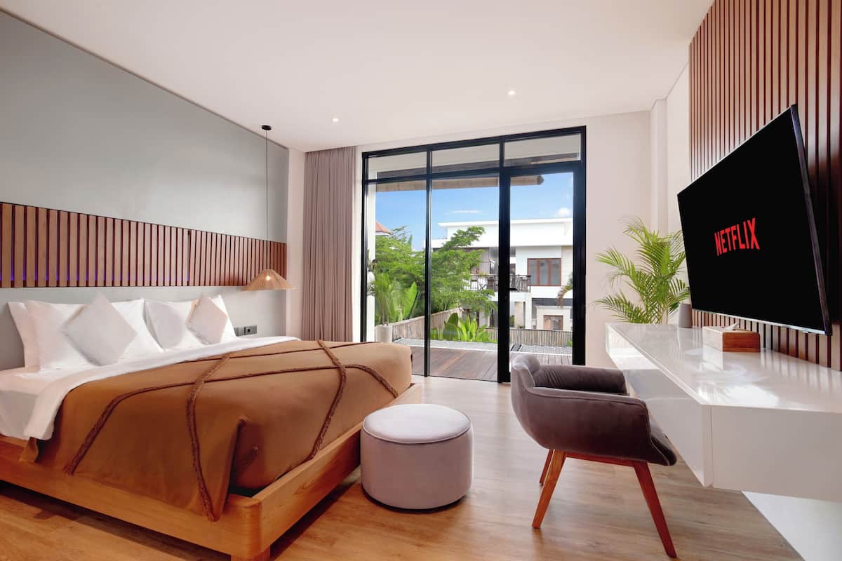 Un dormitorio moderno con una cama grande, un televisor y un balcón con vistas.
