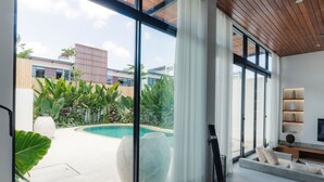 A modern interior with large windows, a pool, and a view of buildings outside. - Paradise Living Villa Canggu (Canggu)