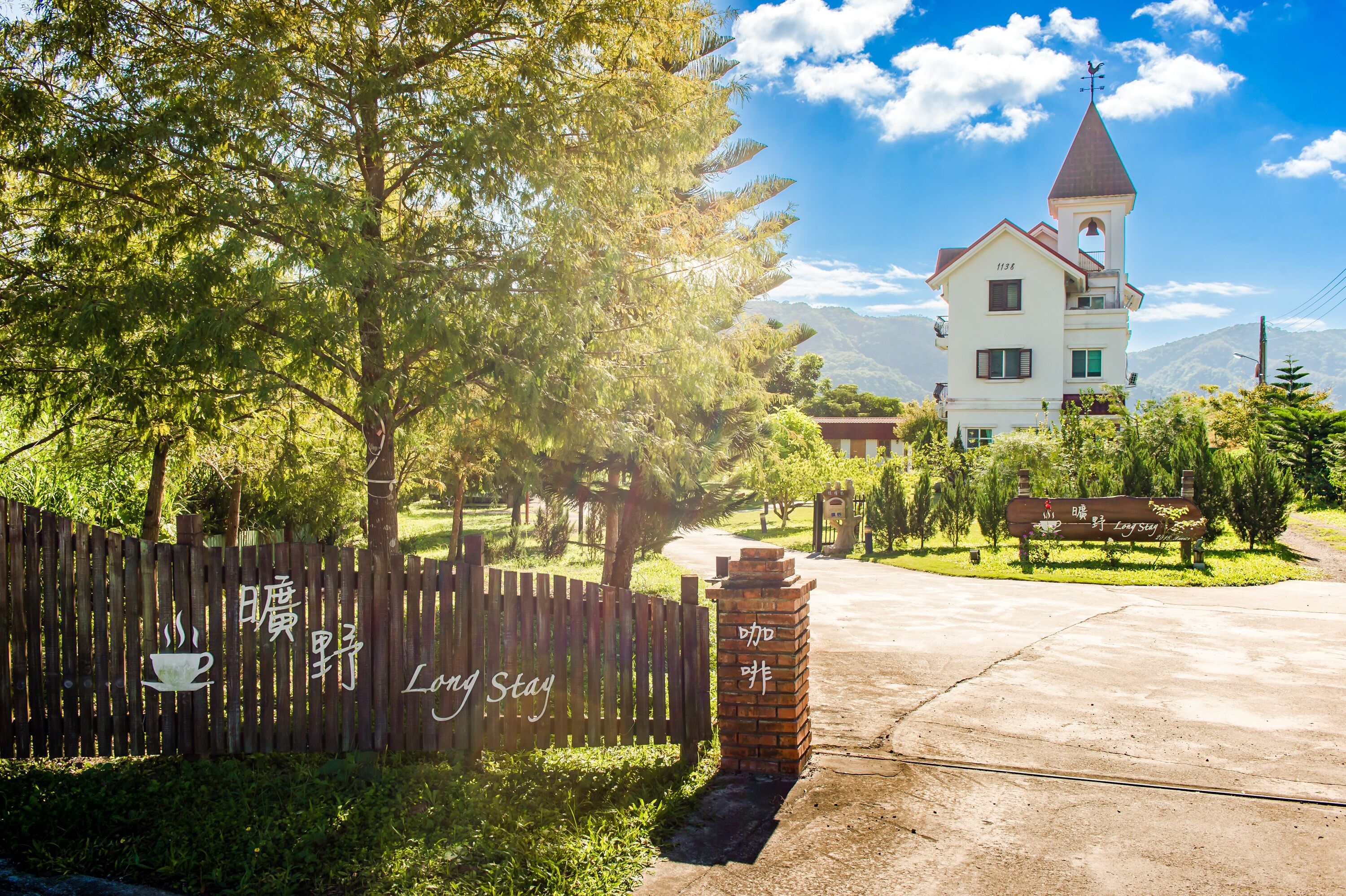 A building with a tower, surrounded by trees and a clear sky.