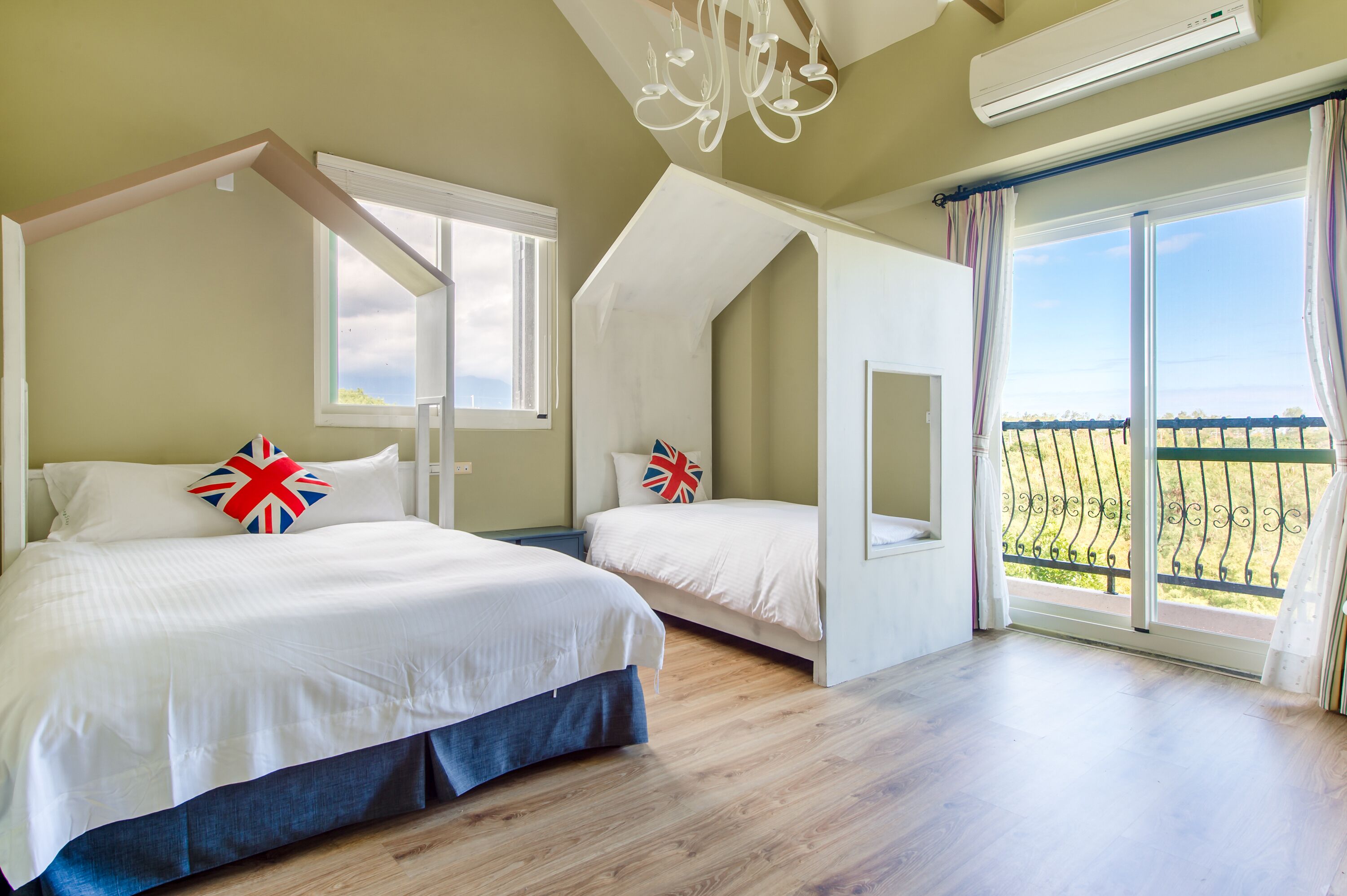Ein Schlafzimmer mit zwei Betten, einer Kandelaber, einer Klimaanlage und einem Balkon mit Blick.