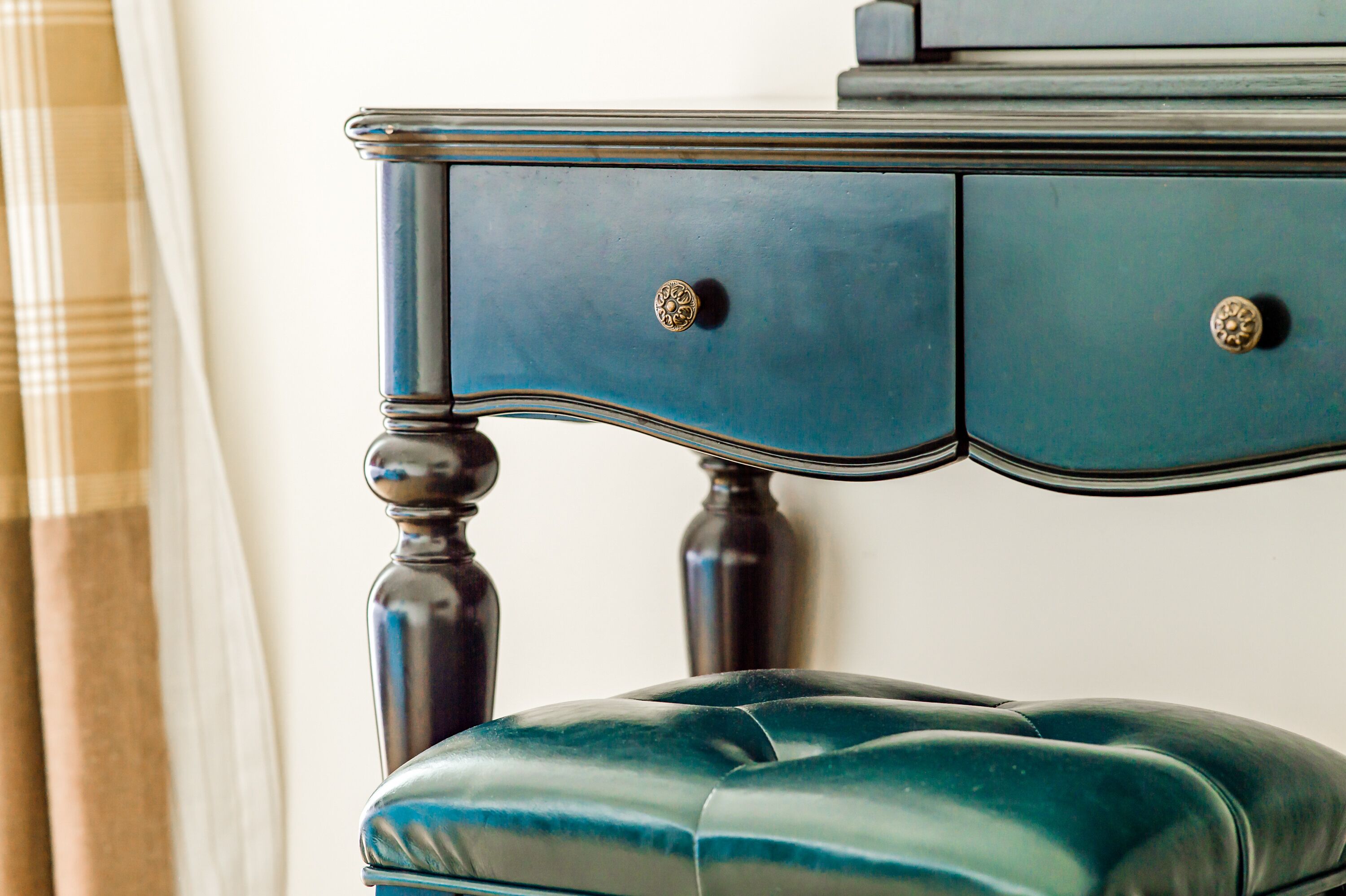 A dark blue dresser with two drawers and a matching ottoman.