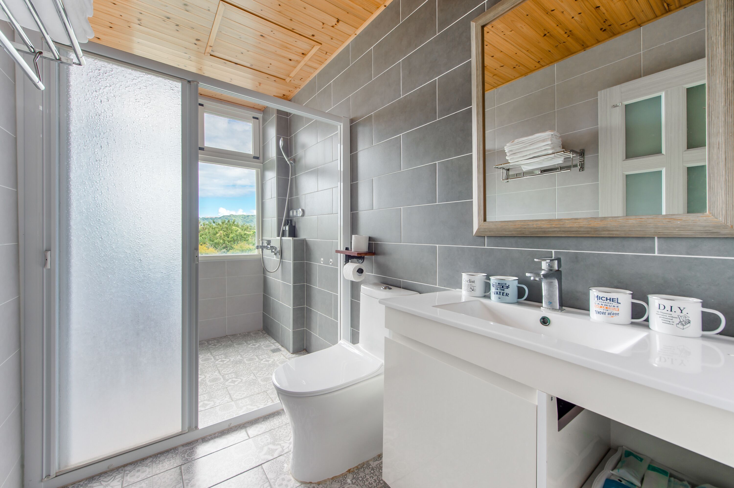 A modern bathroom with a shower, toilet, and sink.