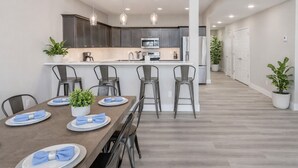 A modern kitchen with dark cabinets, a central island, and pendant lighting. - Big Family Lake Retreat | 6BR Table Rock (Cape Fair)