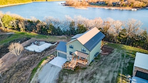 A two-story house with a garage, a covered porch, and a small deck. - Big Family Lake Retreat | 6BR Table Rock (Cape Fair)