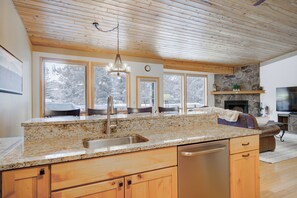 Enjoy cooking in this well-equipped kitchen with a granite countertop, dishwasher, and comfortable seating area.