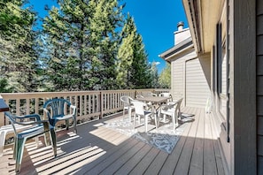 Enjoy outdoor dining or relaxation on this deck surrounded by trees.