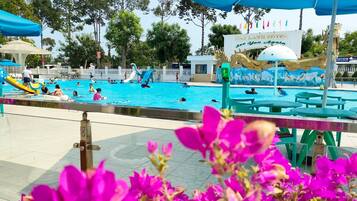 Relax and play in our pool area, featuring water slides and play structures for kids, plus comfortable seating and shaded areas.