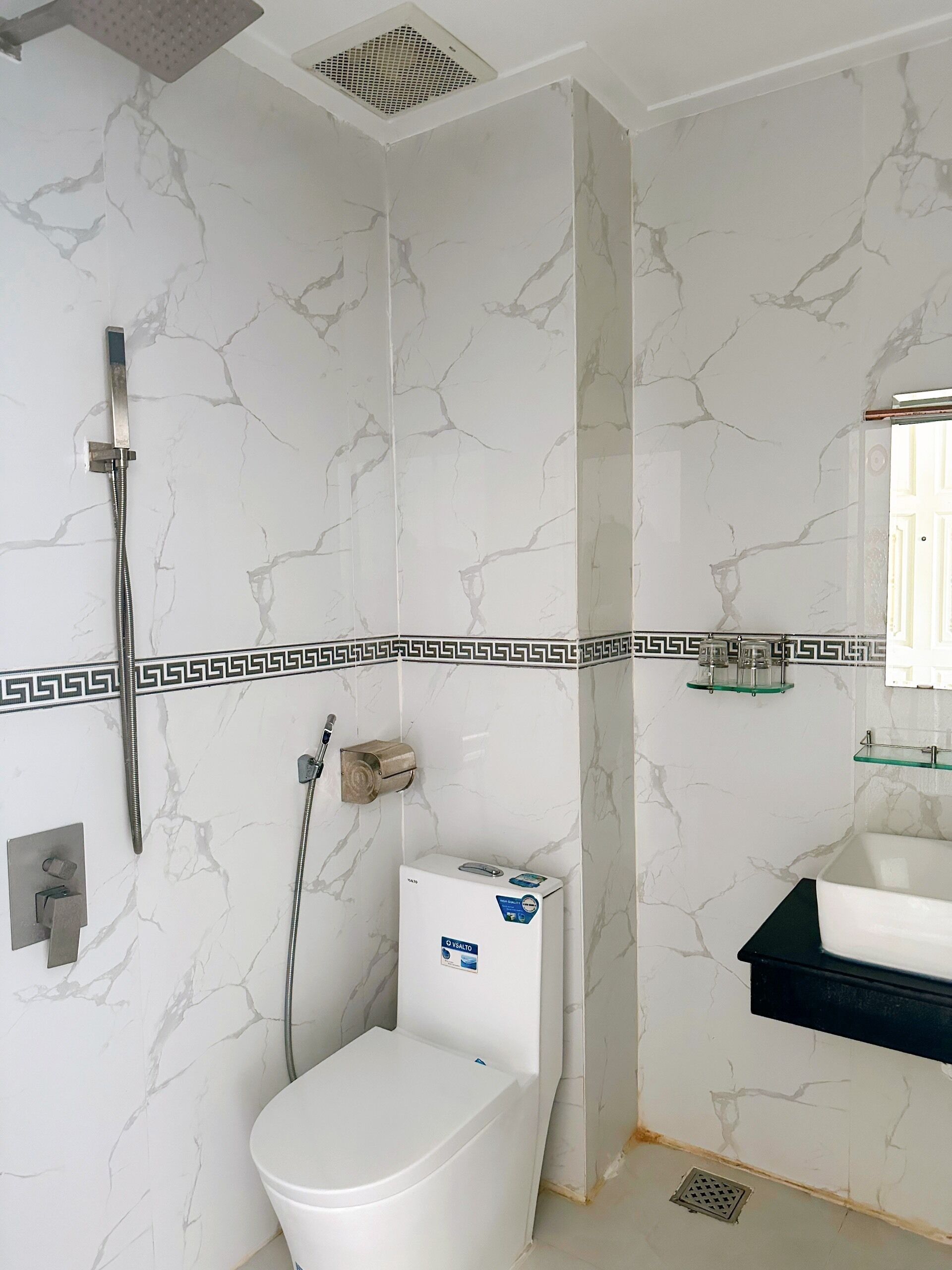 Un baño con inodoro, ducha y lavamanos.