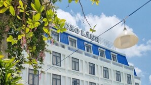 A hotel with a white facade, blue accents, and multiple windows. - Cao Lanh Hotel (My Tho)