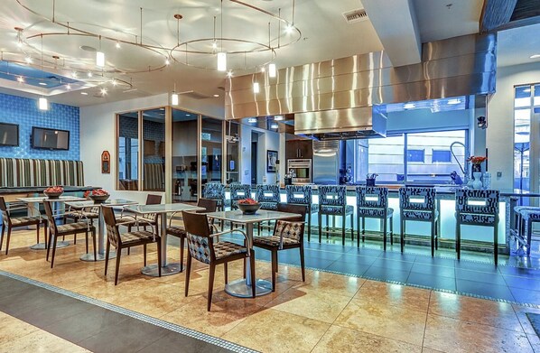 Relax in our spacious lobby with a seating area featuring tables and chairs, a large kitchen, and contemporary ceiling fixtures.