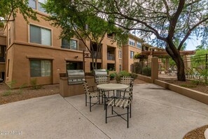 Enjoy al fresco dining on the patio with a round table and four chairs, accompanied by a grill for outdoor cooking.