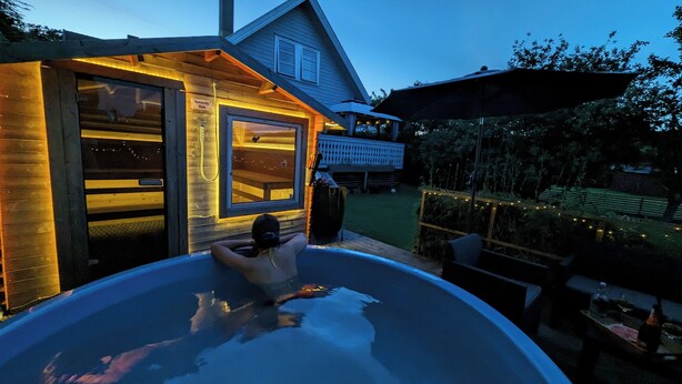 Un jacuzzi frente a una cabaña de madera con un cartel que dice "Serenity Spa".