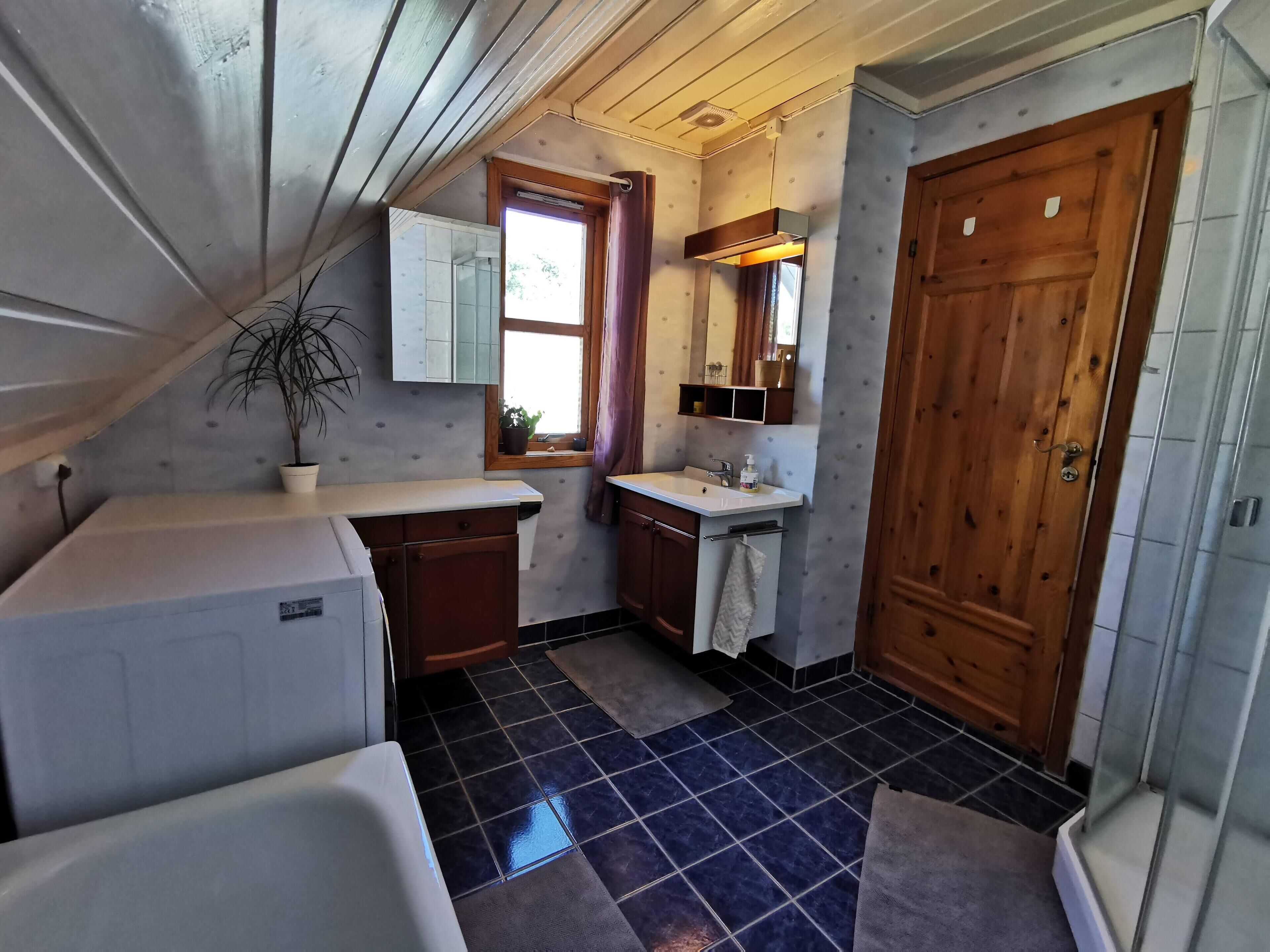 A compact kitchen with a sink, a window, and a door.