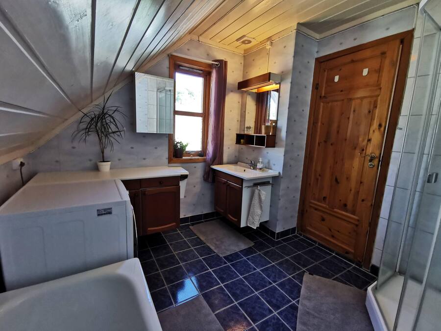 A compact kitchen with a sink, a window, and a door.