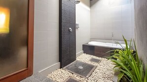 Un baño moderno con ducha, bañera y retrete.