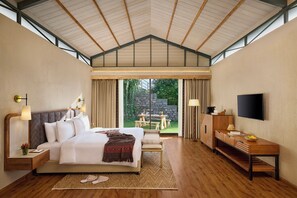 A bedroom with a large bed, bedside tables, a desk, a TV, and a view of the outdoors. - Storii by ITC Hotels The Kaba Retreat (Solan)