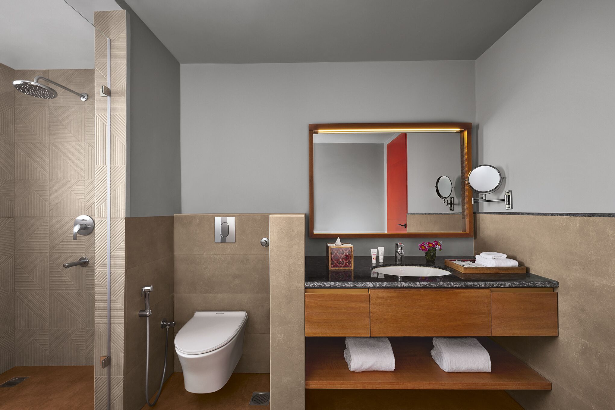 A modern bathroom with a shower, toilet, vanity with a mirror, and a sink.