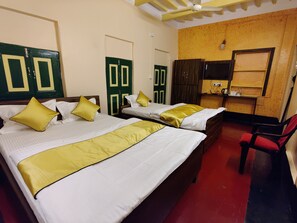 A hotel room with two beds, a desk, and a chair. - Tulin Heritage Bungalow (Purulia)