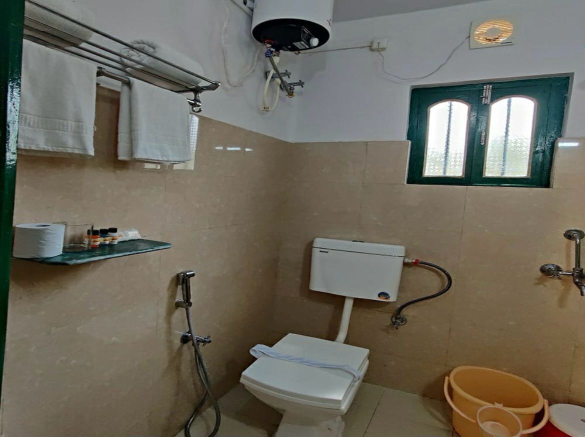 Un baño pequeño con inodoro, ducha y ventana.