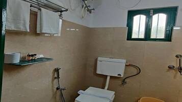 Un baño pequeño con inodoro, ducha y ventana.
