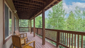 Une terrasse en bois offrant une vue sur une forêt.