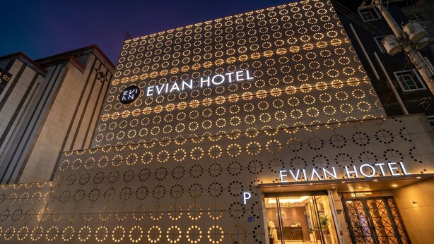 El exterior del Hotel Evian, con un diseño circular distintivo en la fachada y un cartel de hotel visible.