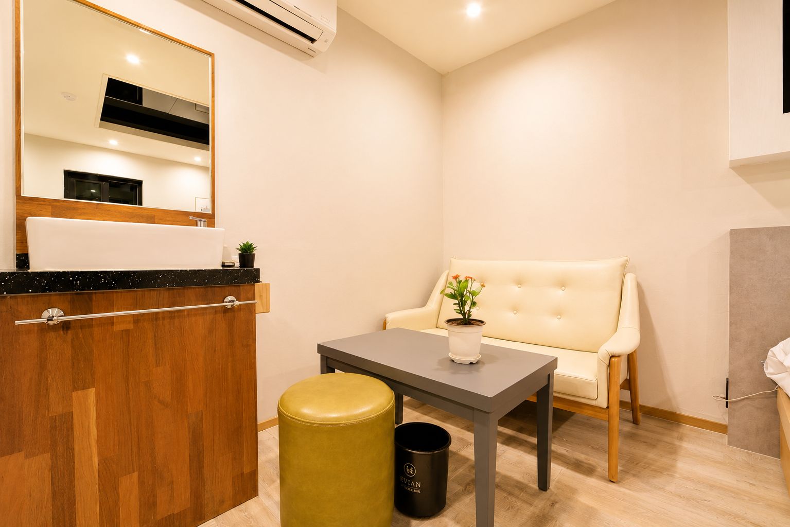 Un baño moderno con un tocador de madera, un espejo, un lavamanos y un inodoro.