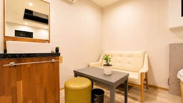 Un baño moderno con un tocador de madera, un espejo, un lavamanos y un inodoro.