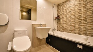 Un baño moderno con inodoro, lavamanos y bañera.